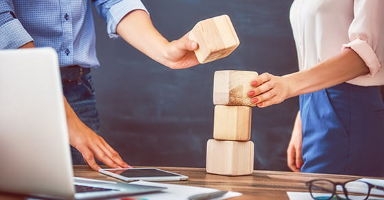 Business people stacking wooden blocks