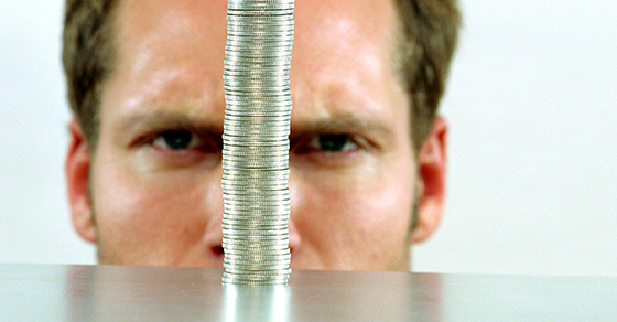 Man looking at a stack of quarters